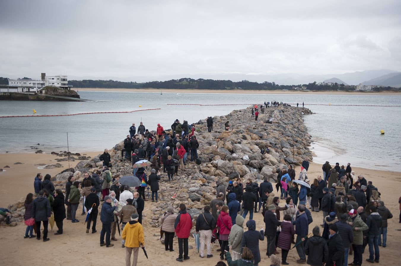 Decenas de personas se han subido este domingo a uno de los dos espigones que se están construyendo para la estabilización de la playa de la Magadalena de Santander para expresar su rechazo a la obra