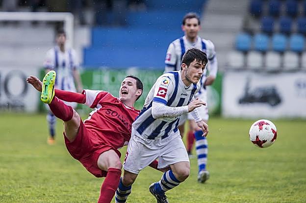 Fermín, de la Gimnástica, conduce el balón, dejando atrás a Cristian, del Barreda. :: roberto ruiz