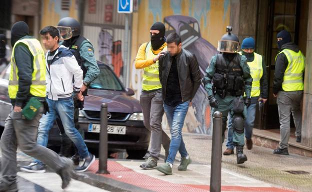 Momento en el que los guardias civiles se llevan a los dos detenidos en el nº11 de la calle Liébana de Santander.