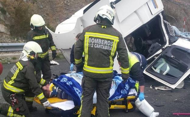 Los bomberos y sanitarios auxilian al herido tras excarcelarle de la cabina