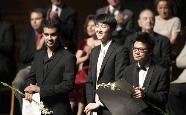 El pianista sevillano Juan Pérez Floristán (i) tras ser nombrado ganador del XVIII Concurso Internacional de Piano de Santander Paloma O´Shea, acompañado por el segundo premio, el coreano David Jae-Weon (c) y por el tercer premio, el chino Jianing Kong (d), durante la final de 2015 en el Palacio de Festivales de Cantabria.