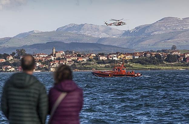 Dos personas observan en la tarde del martes el operativo de rescate frente al Centro Botín de Santander.