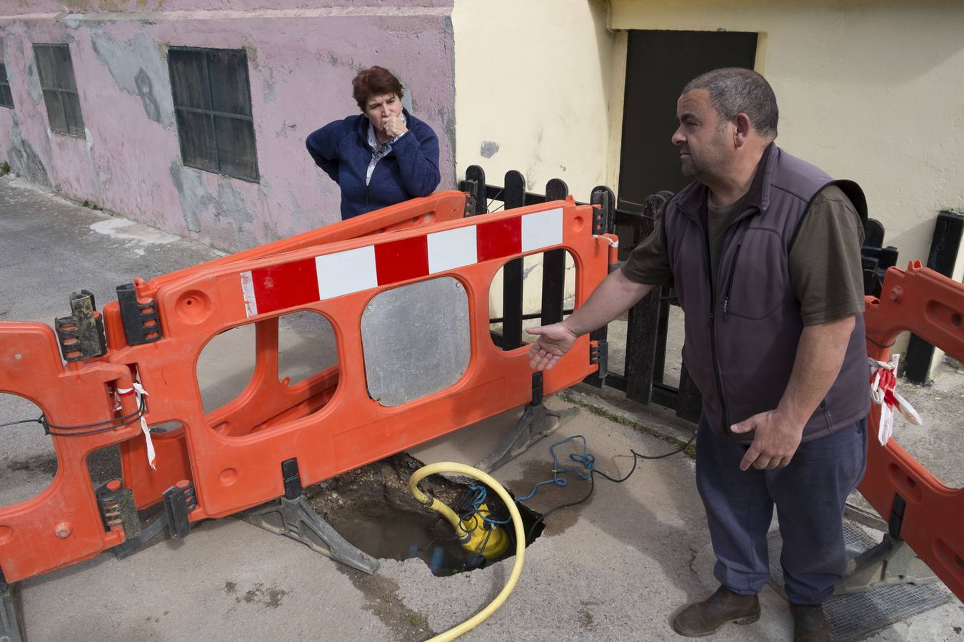 Francisco Javier Muñiz y Conchi Recio muestran la última fuga en su red de abastecimiento, las arquetas de pluviales que se desbordan cada vez que llueve, las bombas de achique que usan los vecinos para que no se les inunden los bajos...