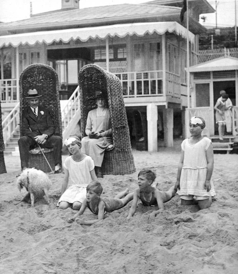 La reina Victoria Eugenia acompañada por el conde de Albany, observan a los infantes mientras juegan en la playa de El Sardinero. 