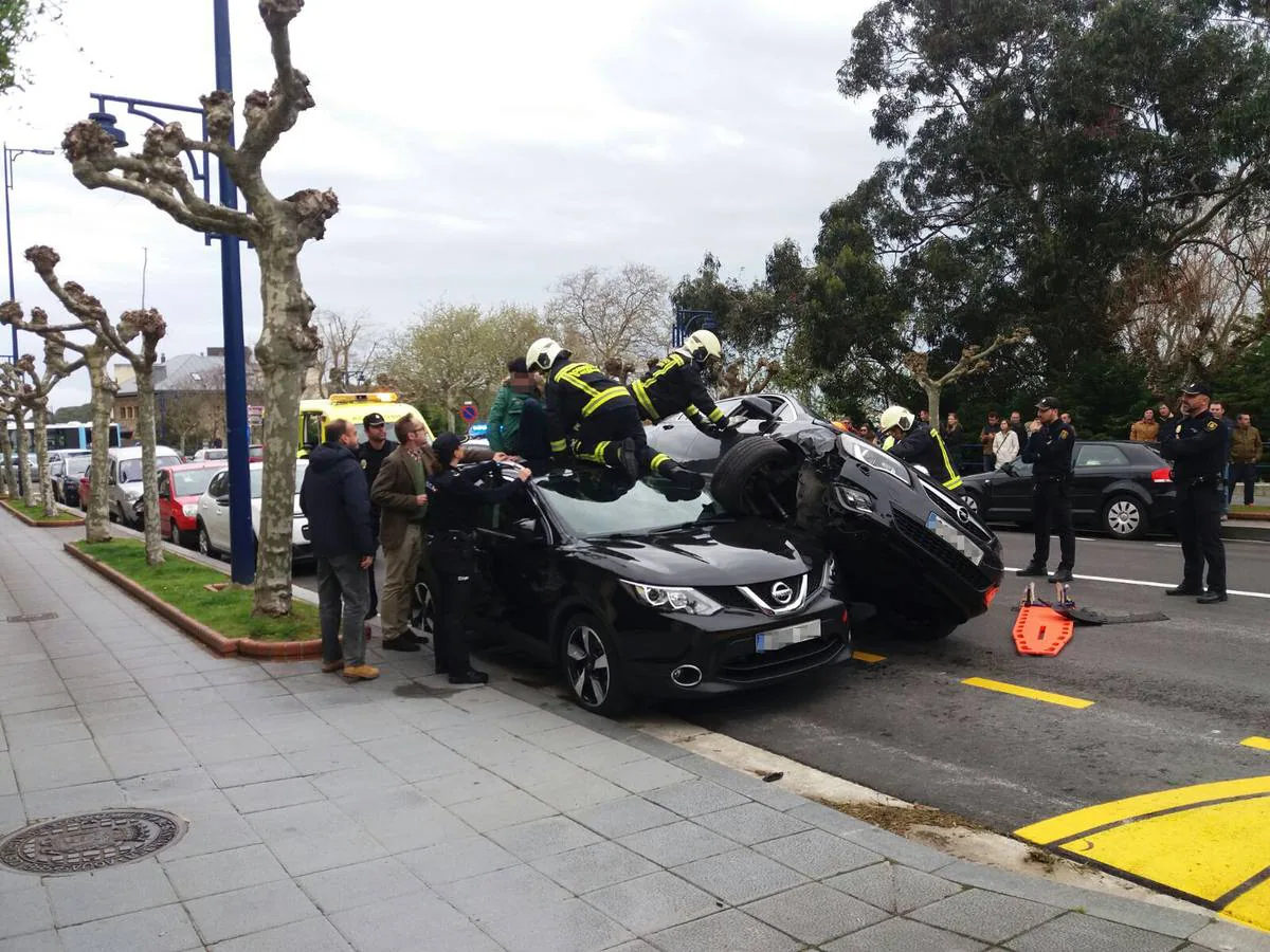 Los bomberos ayudan a uno de los ocupantes a abandonar el vehículo.