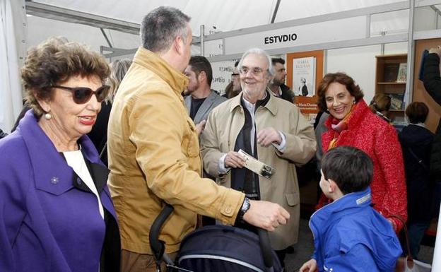 Gutiérrez Aragón saludando en los stands de la Feria del Libro de Torrelavega 