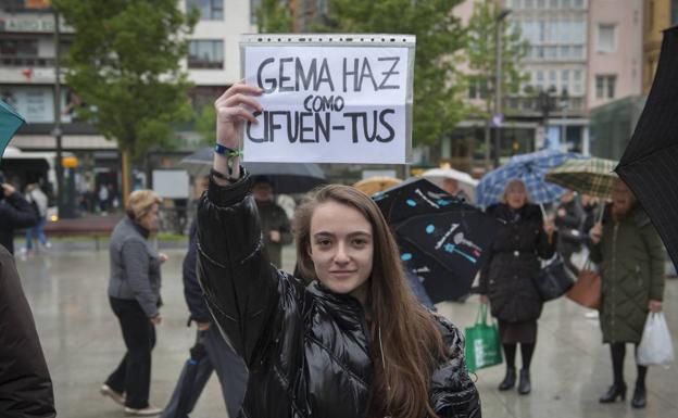 Una joven muestra una pancarta durante la concentración.