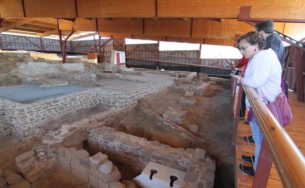 Un grupo de visitantes contempla el yacimiento bajo la nueva cubierta. 