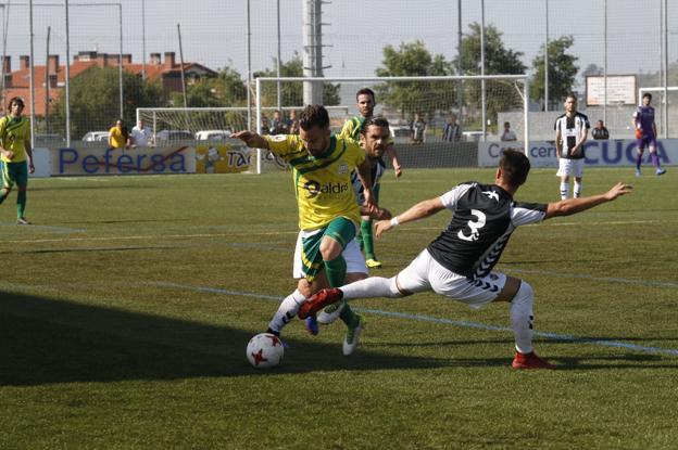 Kike, del Castellón, trata de frenar a Isuardi, del Tropezón. 