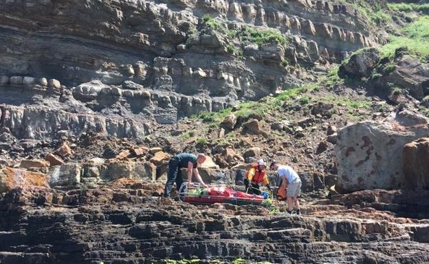 Agentes de la Guardia Civil y miembros del equipo de rescate inmovilizan al herido.