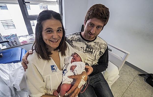 La pequeña Manuela en brazos de su madre, Marta, y junto a su padre, Borja, quien ayudó a traerla al mundo en su propia casa.