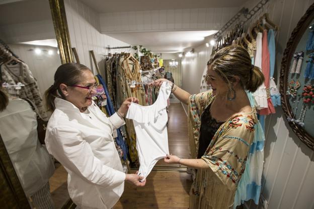 María Díez, de Must, enseña a una clienta (izquierda) un traje de baño blanco de esta temporada. 