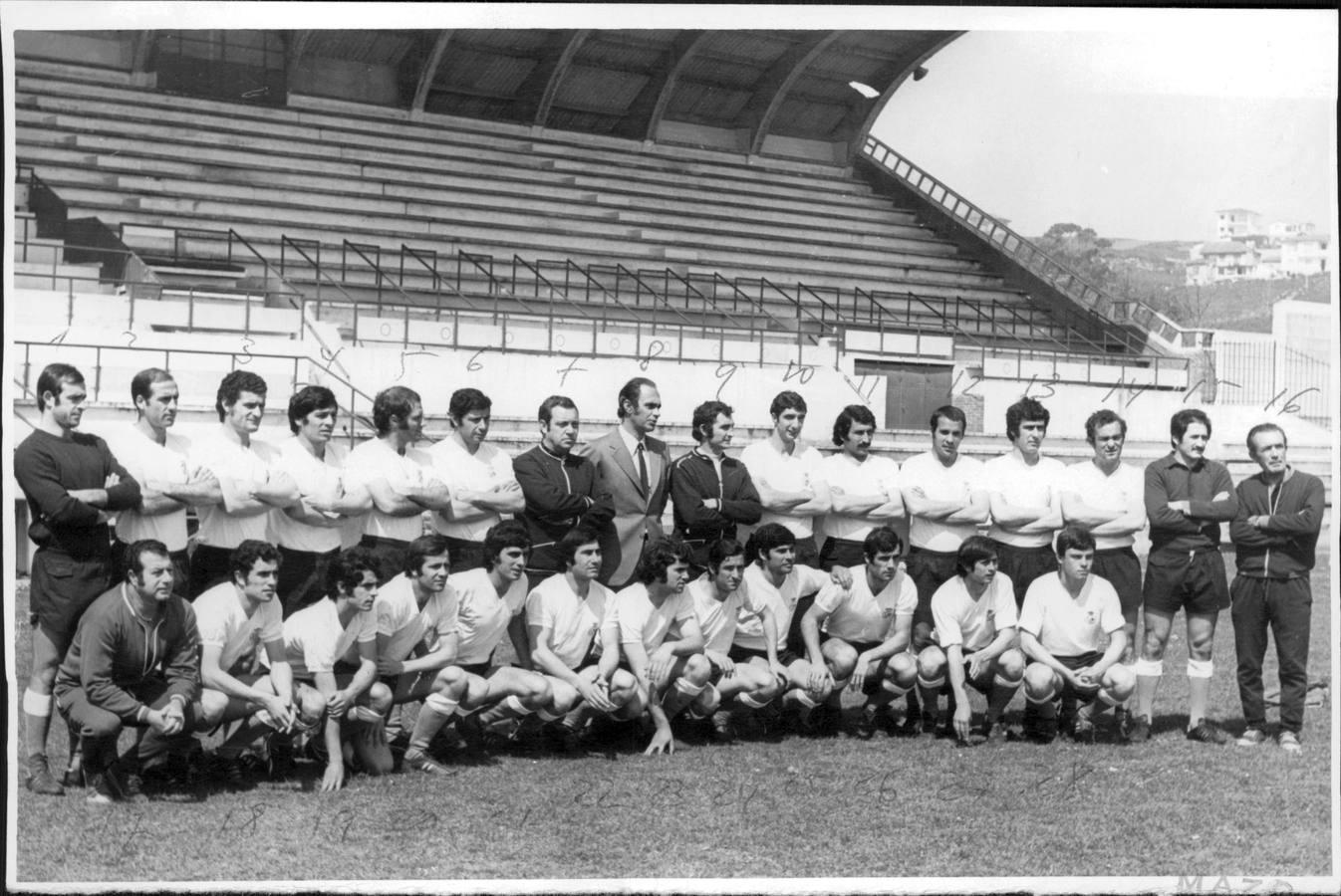 Foto del equipo en la temporada 72-73, el mítico 'Racing de los Bigotes', a principios de la campaña. En esta imagen, los jugadores posan con el presidente, Valentín Valle; el entrenador José María Maguregui; y el recordado utillero racinguista Terio. Detrás de ellos, la grada preincipal del estadio del Sardinero.