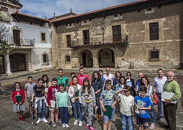 Los niños y adolescentes del muncicipio, junto a representantes muncipales, ante el Ayuntamiento de Camargo.