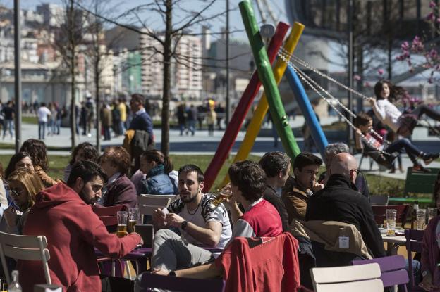 .Varias personas disfrutan en las terrazas de los Jardines de Pereda.