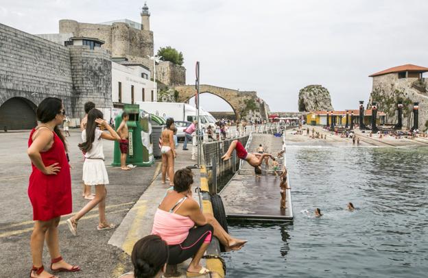 Una de las estampas habituales del verano en Castro Urdiales de jóvenes dándose un baño en la zona del puerto. 