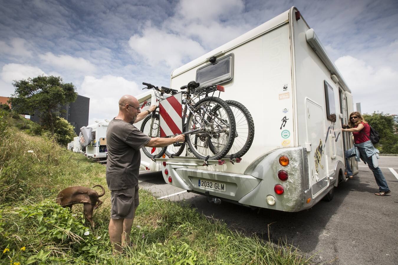 Dos turistas comprueban que todo está listo en su autocaravana antes de abandonar el área de servicio de las Llamas