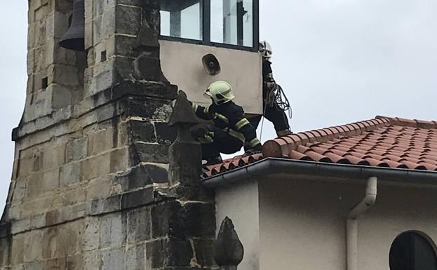 Los bomberos, asegurando la estructura de la ermita.