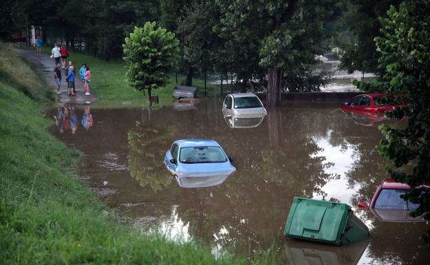 Imagen principal - Una tromba de agua inunda un aparcamiento de Santillana del Mar y afecta a 60 vehículos