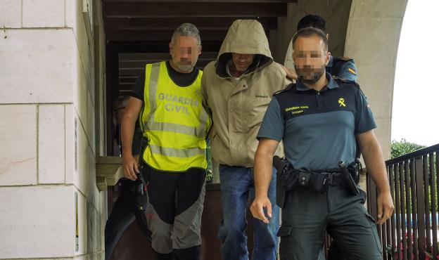 Tres agentes custodian a Luciano Simón a la salida del cuartel de la Guardia Civil.