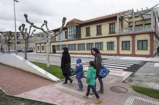 Unas madres pasean a sus hijos frente al edificio de las oficinas de Cros, en Maliaño.