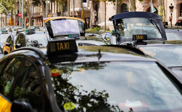 Taxistas en huelga ocupan, hoy domingo, por tercer día, la Gran Vía de Barcelona en protesta por la concesión de licencias a vehículos de transporte con conductor (VTC). 