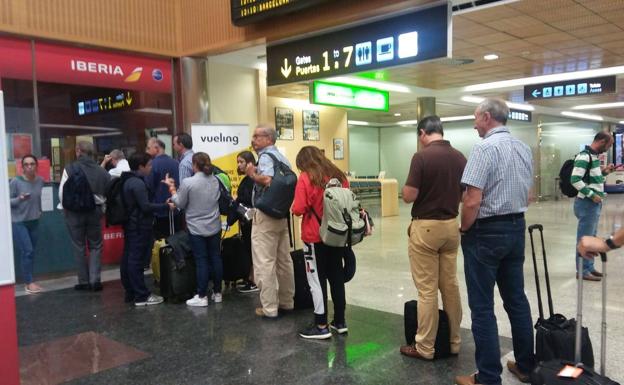 Los pasajeros hicieron cola en los mostradores de Iberia para gestionar una recolocación en otros vuelos, antes de saber que la avería de su avión iba a solucionarse.