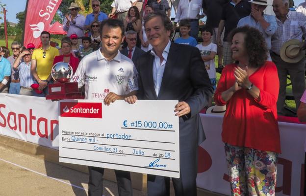 Óscar González recibe el trofeo y el cheque que le acredita como ganador de manos de Carlos Hazas