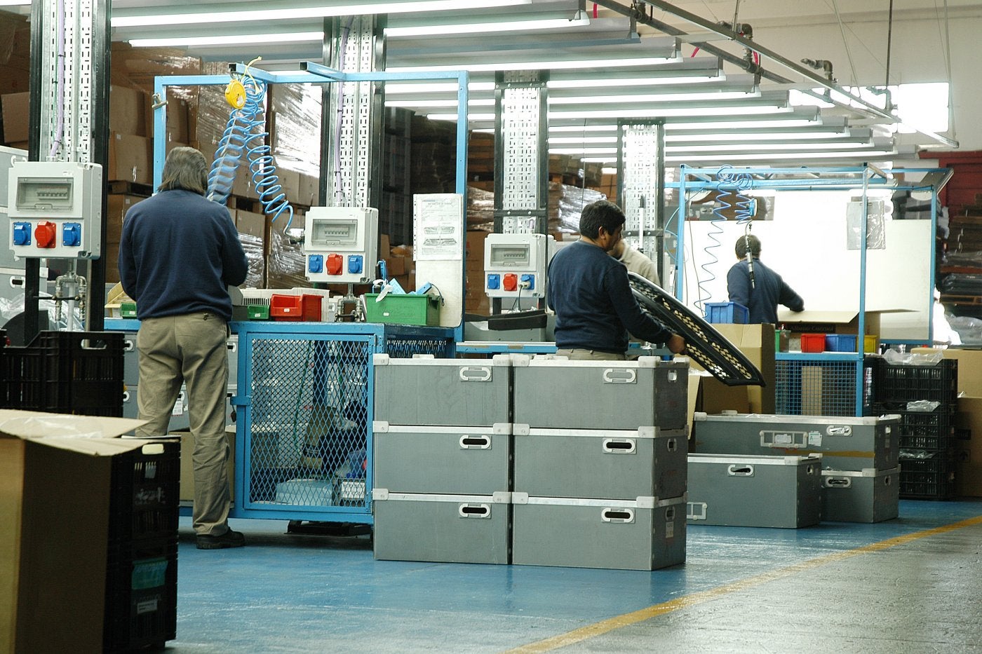 Varios trabajadores en una nave industrial.