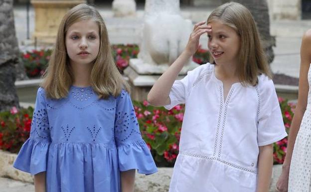 Imagen principal - Arriba, las infantas Leonor y Sofía. El modelo de Zara utilizado por Leonor en el posado de Palma de Mallorca se agotó a las pocas horas. Cuesta 22,95 euros. Abajo, a la izquierda, Meghan Markle, la esposa del príncipe Enrique de Inglaterra, es ahora mismo la prescriptora de tendencias más importante. Ajabo a la derecha, la hija de la infanta Elena ha hecho famosa su falda desteñida.Es de una firma sevillana y cuesta menos de 20 euros. 