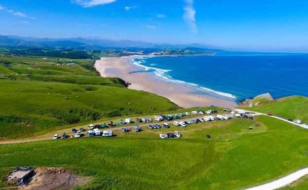 Vista aérea de la playa de Merón y de uno de los terrenos habilitados para aparcamiento diurno de autocaravanas.