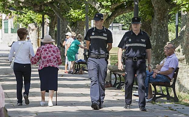 Dos agentes de la Policía Local de Santoña patrullan por una calle de la villa. :