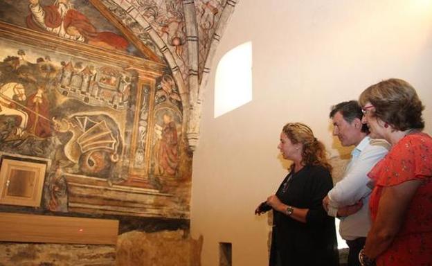 La restauradora muestra a Mañanes y Ranea los trabajos realizados en las pinturas de la iglesia de Ledantes. Fotografía: Pedro Álvarez