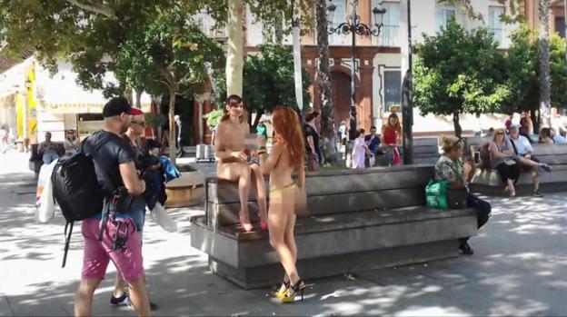 Dos actrices desnudas charlan en una pausa de un rodaje en una plaza sevillana. 