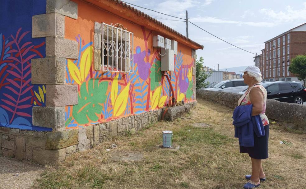 Una viandante contempla el mural de Sandra Suárez.