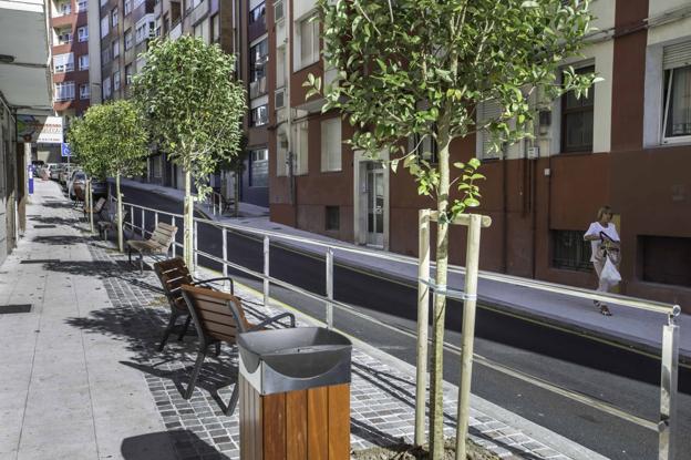 Una de las nuevas zonas estanciales de la calle Jiménez Díaz, con árboles, sillas y papelera. 