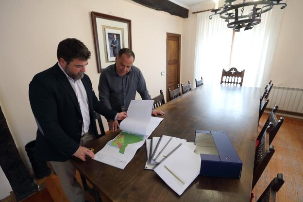 El alcalde, Víctor Manuel Reinoso, (a la derecha) y el exarquitecto municipal revisan el documento del Plan General. 