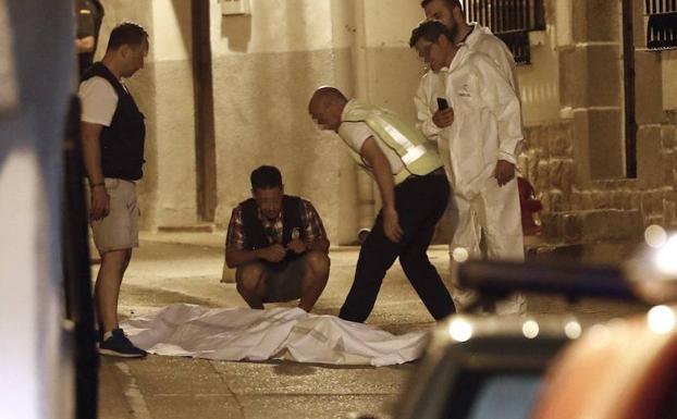 Efectivos policiales junto al cuerpo de una de las tres personas fallecidas. 