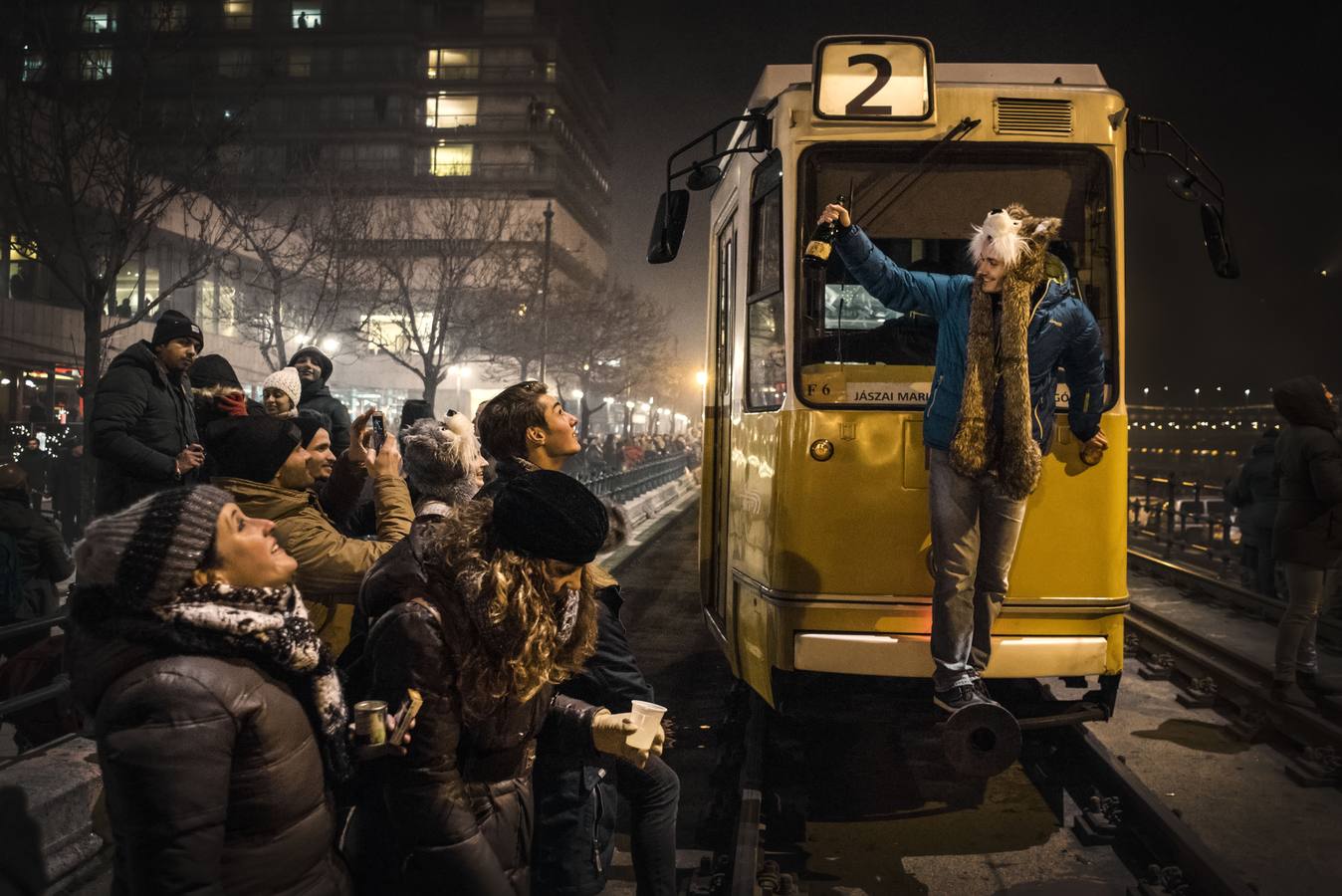 Una joven celebra la entrada del año 2017 subida en la parte frontal de un tranvía en Budapest, tras pararse éste por seguridad, ya que las vías se encontraban llenas de personas. 