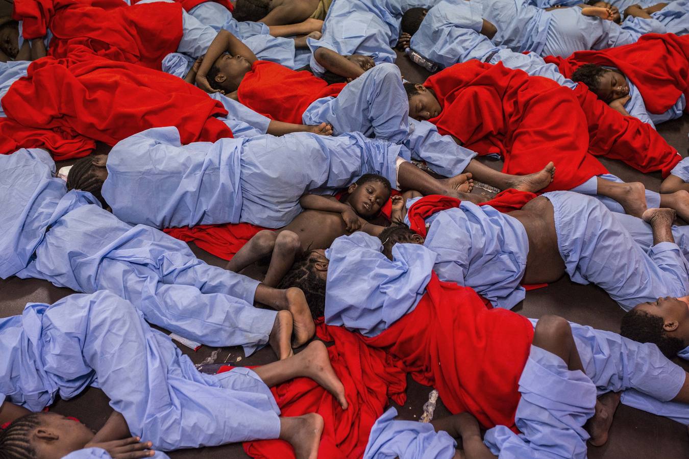 Decenas de mujeres y niños duermen en el interior del barco de rescate Golfo Azzurro, de la ONG Proactiva Open Arms, después de ser rescatados a 29 millas de Libia, cuando viajaban en un bote de goma intentando llegar a Europa. 