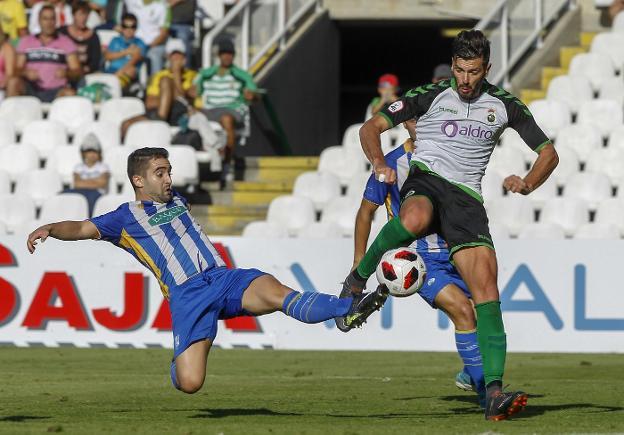 Dani Segovia trata de rematar a portería ante la oposición de un jugador de la Cultural de Durango.