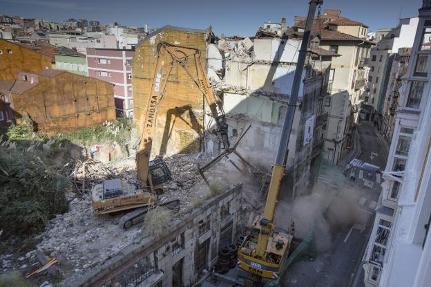 El edificio número 1 de la calle San Pedro y el 26 de la Cuesta del Hospital, ayer durante el inicio de las obras de demolición.