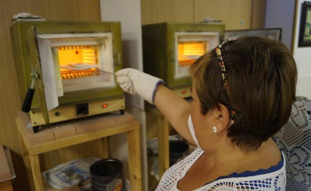 Una alumna utiliza el horno en esmalte a fuego.