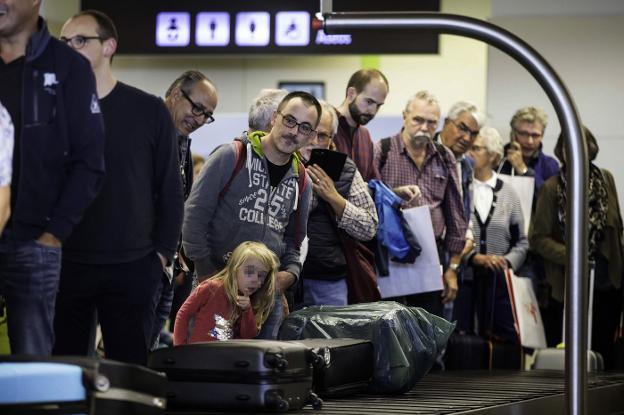 Varios turistas esperan su maleta en el aeropuerto Seve Ballesteros. 