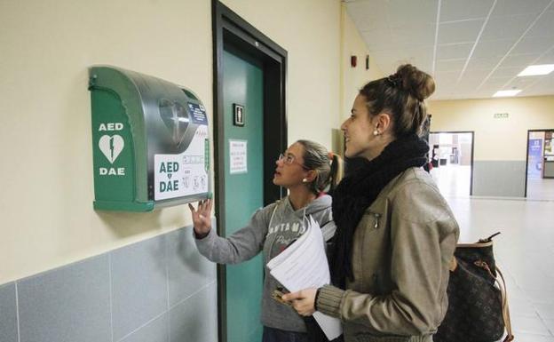 Dos mujeres contemplan el desfibrilador instalado en la facultad de Económicas de la Universidad de Cantabria.