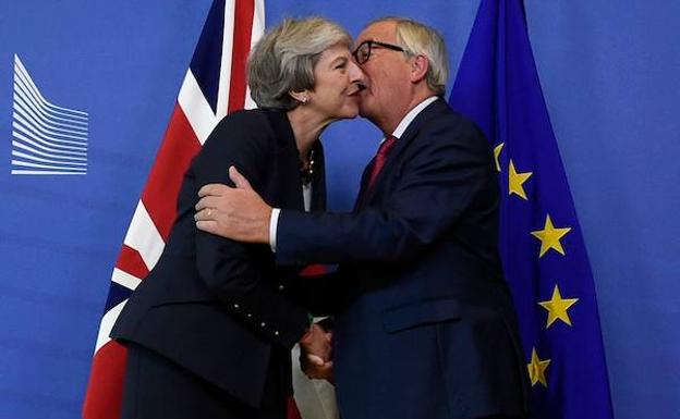 Jean-Claude Juncker saluda, ayer, a Theresa May.