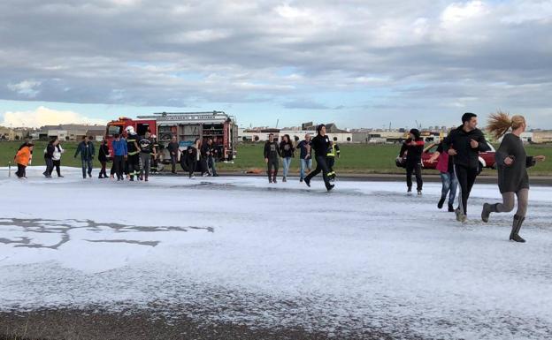 Figurantes del simulacro corren tras un supuesto accidente aéreo.