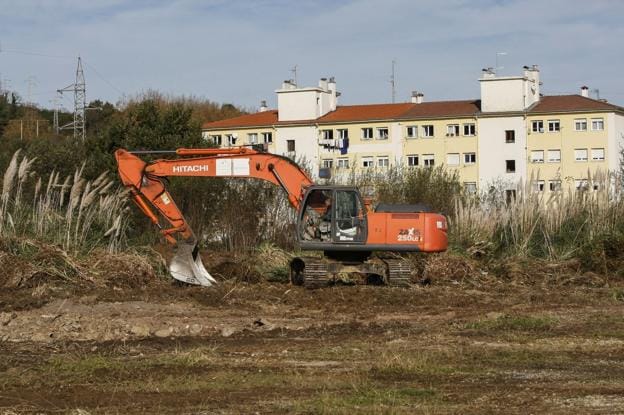 Una máquina excavadora realiza trabajos de desbroce en la finca, cercana a la calle Río Miera.