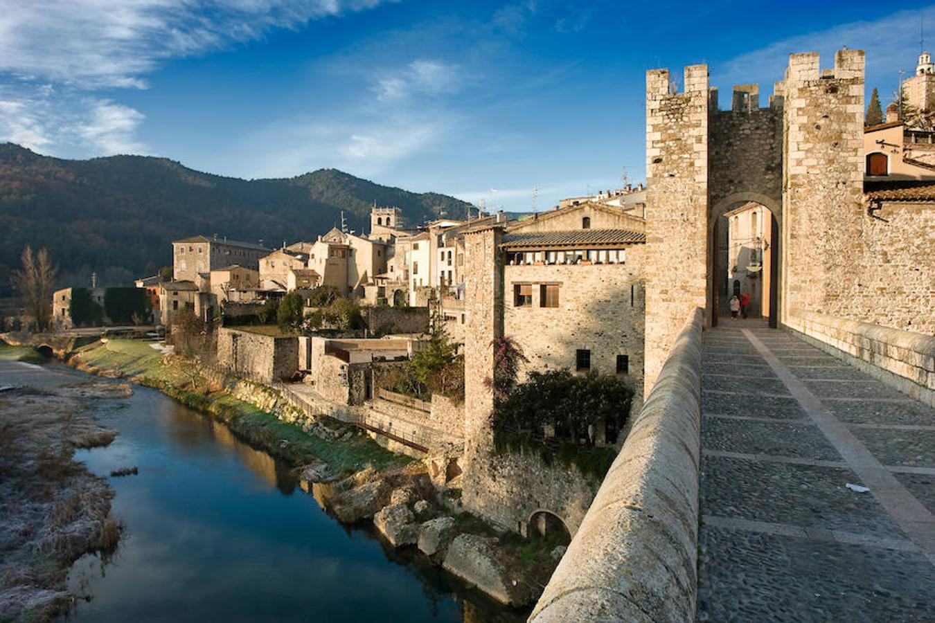 Besalú (Girona) | Una fortaleza medieval entre dos ríos, cerca de la frontera con Francia, donde el tiempo parece haberse detenido por completo. Su imagen es propia de los cuentos de hadas: adentrado en plena montaña, lleno de vegetación, en perfecto estado de conservación y hasta con un castillo. El pueblo fue formándose en torno a la fortaleza y hoy es toda una auténtica postal de siglos pasados. 
