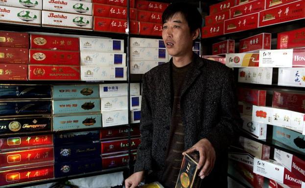 Un hombre vende cartones de cigarrillos en un estanco en Pekín.